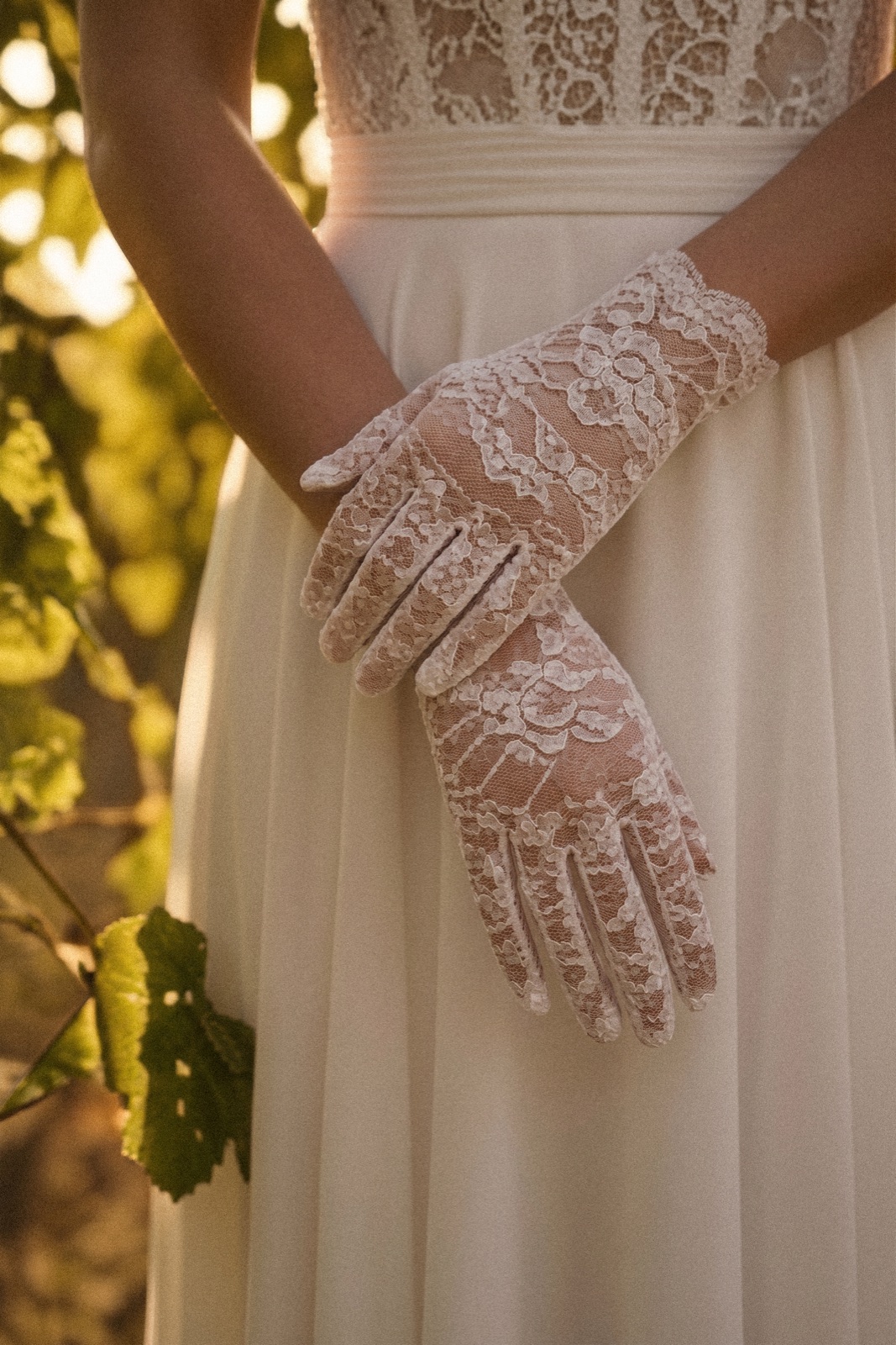 Detail of lace gloves worn in warm light